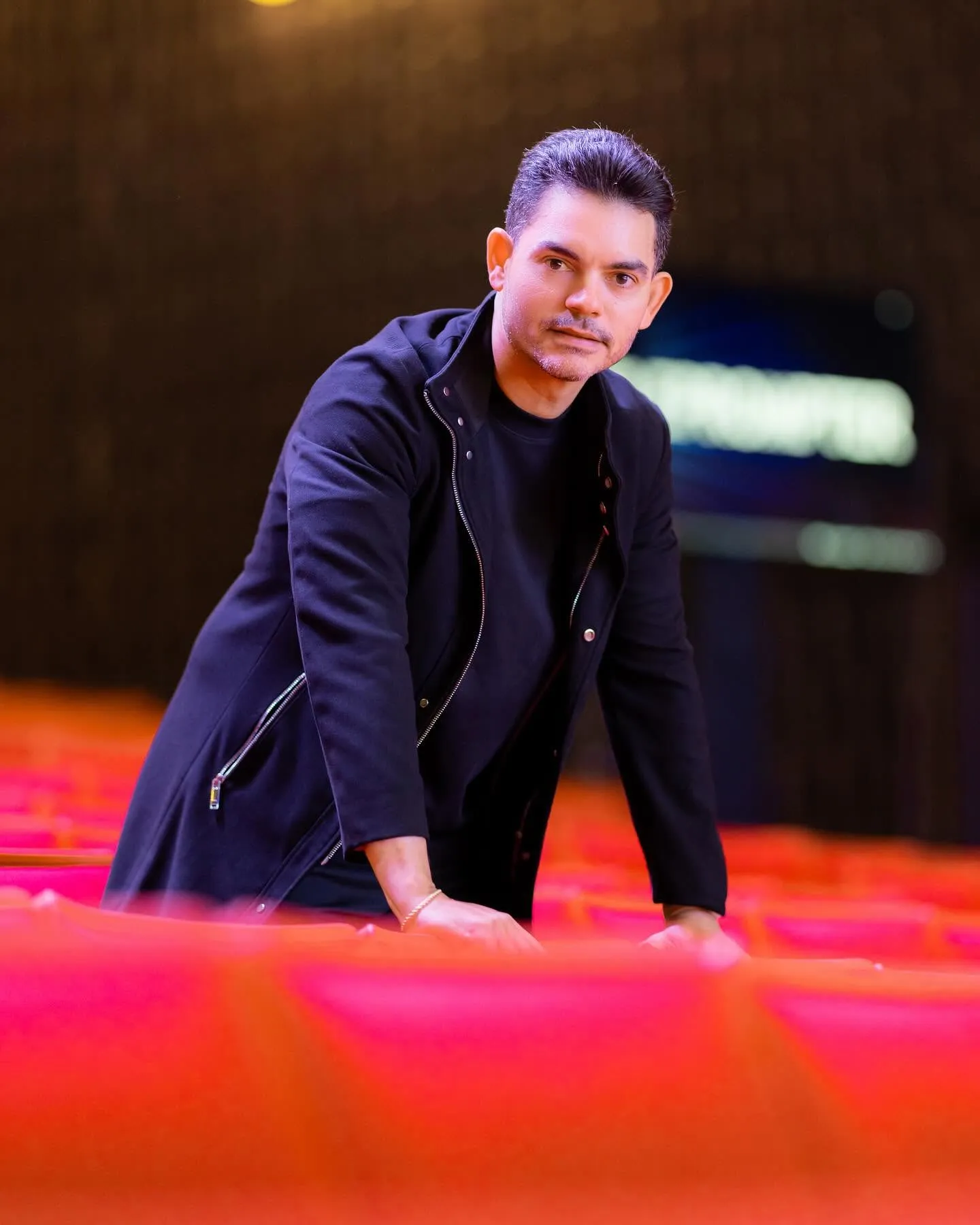 Camilo Then en la sala de un teatro, apoyado sobre las butacas rojas